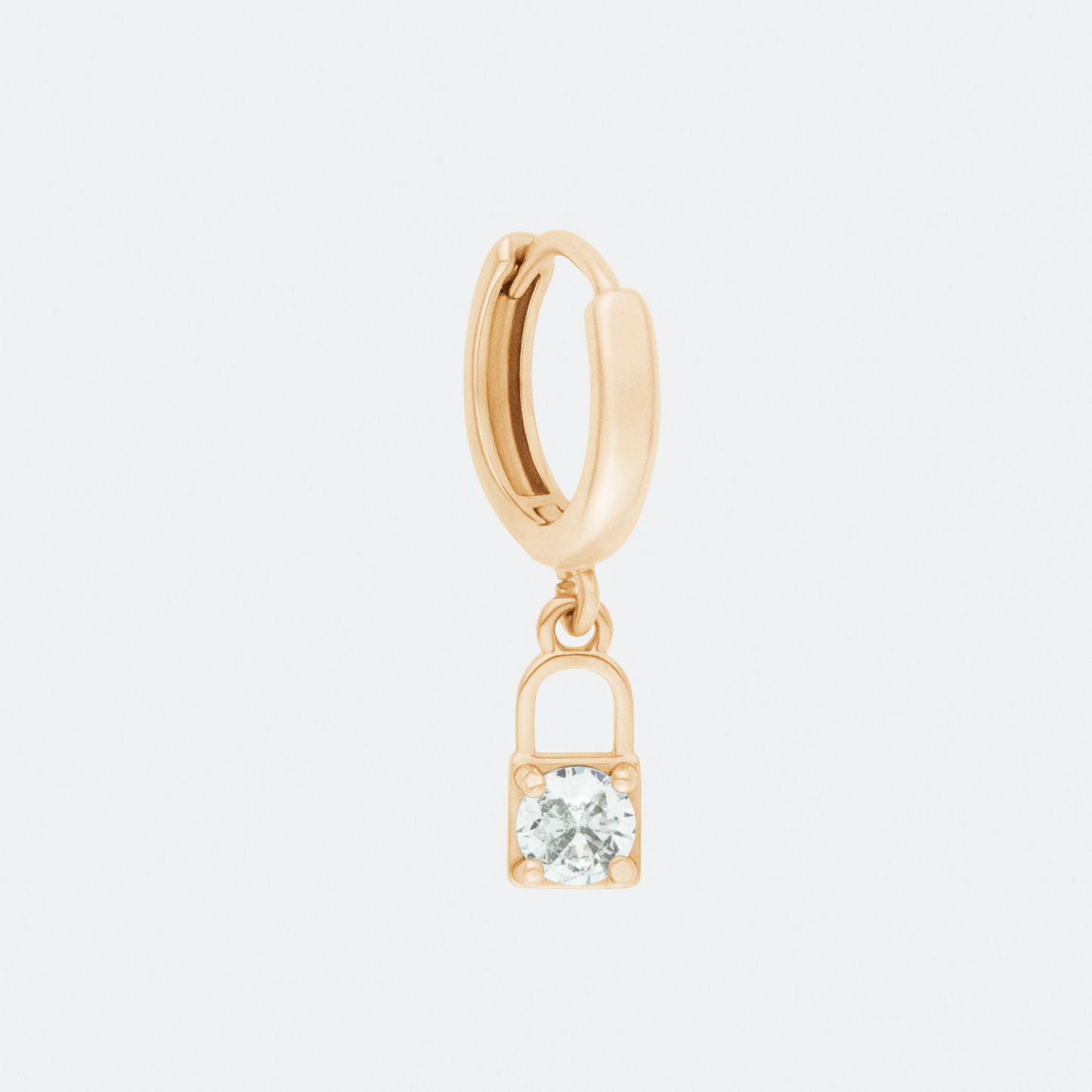 The Amuletum lock charm hoop earring by Ocarina, an 18K gold-plated hoop featuring a delicate dangling padlock charm with a sparkling zircon stone. A symbolic jewelry piece representing security, love, and commitment, displayed against a clean white background.