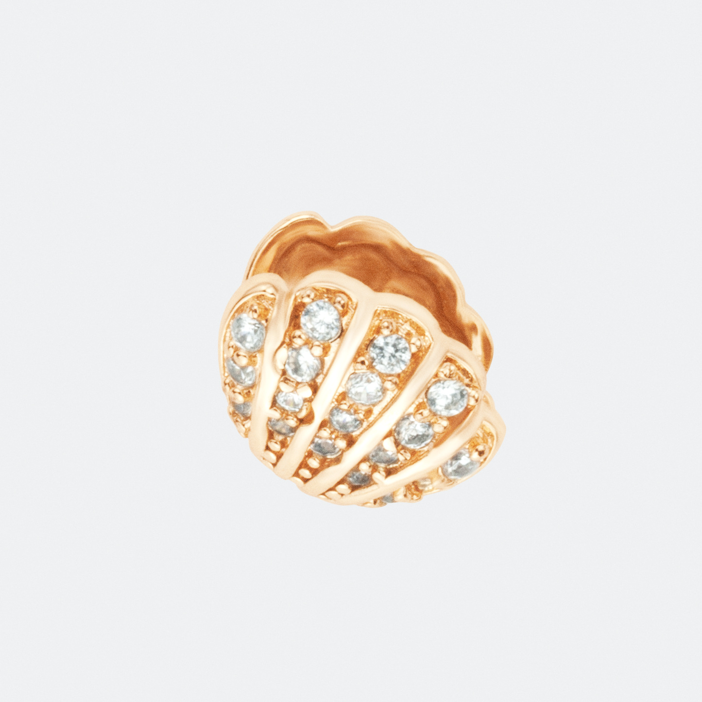 The Concha earrings by Ocarina, 18K gold-plated stud earrings in the shape of seashells, adorned with shimmering zircon stones. A luxurious ocean-inspired jewelry piece capturing the beauty of marine treasures, displayed against a clean white background.