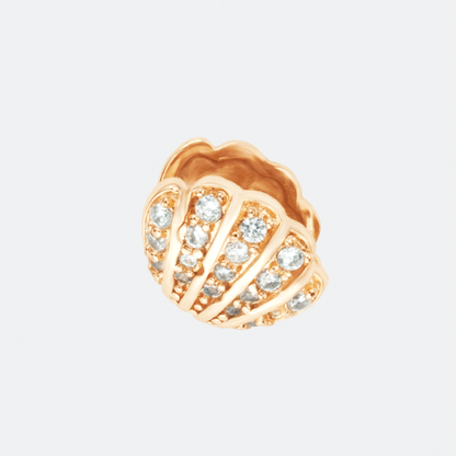 The Concha earrings by Ocarina, 18K gold-plated stud earrings in the shape of seashells, adorned with shimmering zircon stones. A luxurious ocean-inspired jewelry piece capturing the beauty of marine treasures, displayed against a clean white background.