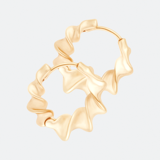 The undae hoop earring by Ocarina, an 18K gold-plated design featuring a sculptural wavy shape inspired by fluid movement. A bold yet elegant statement piece with an organic aesthetic, displayed against a clean white background
