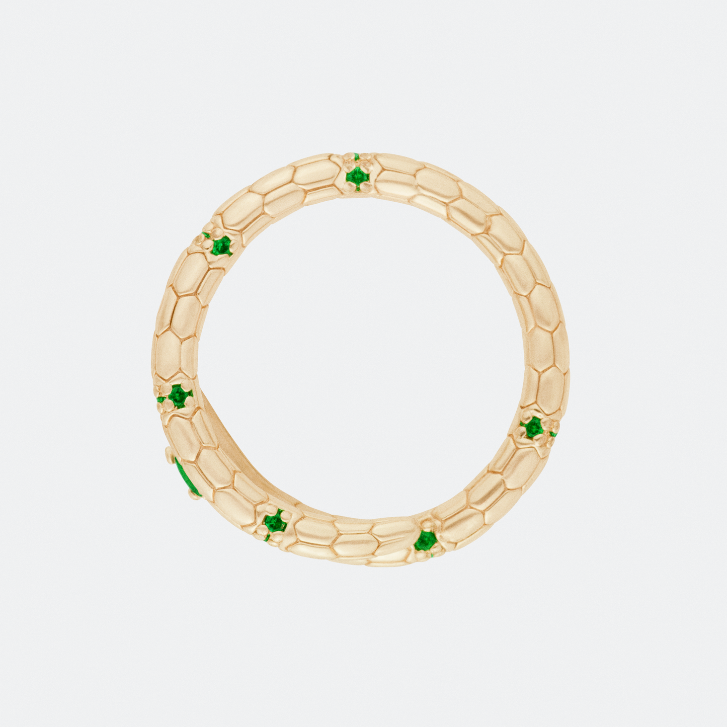 The Serpens ring by Ocarina, a gold-plated snake-inspired design with a textured scale pattern and embedded green gemstones. A bold statement piece symbolizing transformation and strength, displayed against a clean white background