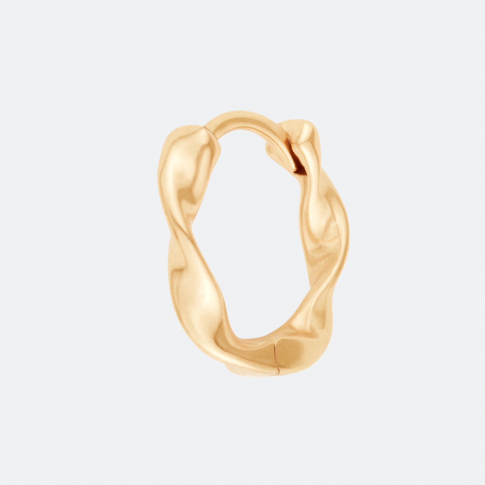 The Undae Mini hoop earring by Ocarina, an 18K gold-plated design with a fluid, organic shape inspired by natural waves. A minimalist yet bold statement piece, displayed against a clean white background