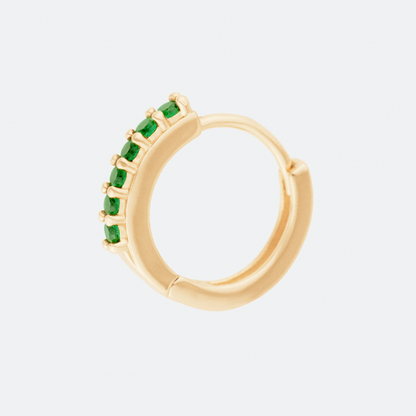 The Viridans hoop earrings by Ocarina, featuring 18K gold-plated hoops adorned with vibrant green gemstones in a prong setting. A delicate yet eye-catching piece that adds a refined touch of color, displayed against a clean white background